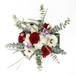 Expertly designed by Dartford's local florists, this bouquet is a study in quiet confidence and refined beauty. At its center are plush red roses, each layer of satin-soft petal symbolizing affection and intention, rising from a bed of luminous white gerbera daisies whose coffee-dark centers lend both stability and visual intrigue. Threads of pale lilac lisianthus, some in bud and others just opening to the world, offer a soft, contemporary accent-like the first blooms spotted along Dartford Heath at dusk. Eucalyptus leaves, rounded and textured, arc gracefully throughout the arrangement, bringing a silvery-green glow and a clean, herbal fragrance that recalls Dartford's fresh morning air. Subtle, clustered filler flowers in ivory hues add cloud-like dimension and an inviting sense of movement. Broad, lustrous green leaves are wrapped at the base, framing the bouquet with a modern flourish. The bouquet is anchored in a crystal-clear vase, through which the vibrant stems and water shimmer in the light. Whether gracing a table in a home near Spital Street or offered as a thoughtful gift for a nearby celebration, this bouquet brings together tradition, freshness, and artistry, making it a cherished choice for marking significant moments throughout Dartford.